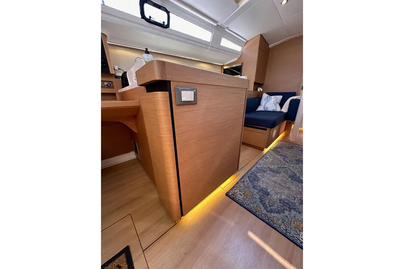Slide: The Image of Interior of 2022 Jeanneau Sun Odyssey 410 yacht with modern wood finish and cozy seating. - 54