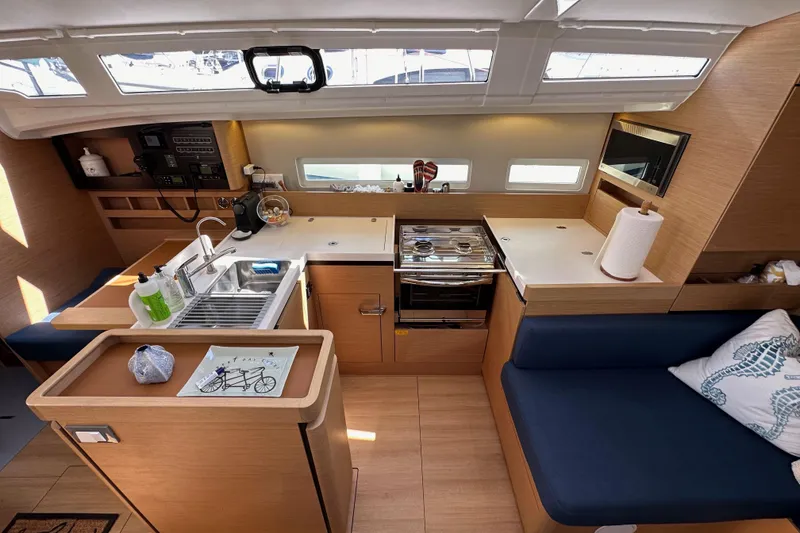 Slide: The Image of Interior of 2022 Jeanneau Sun Odyssey 410 yacht, featuring modern kitchen and seating area. - 55