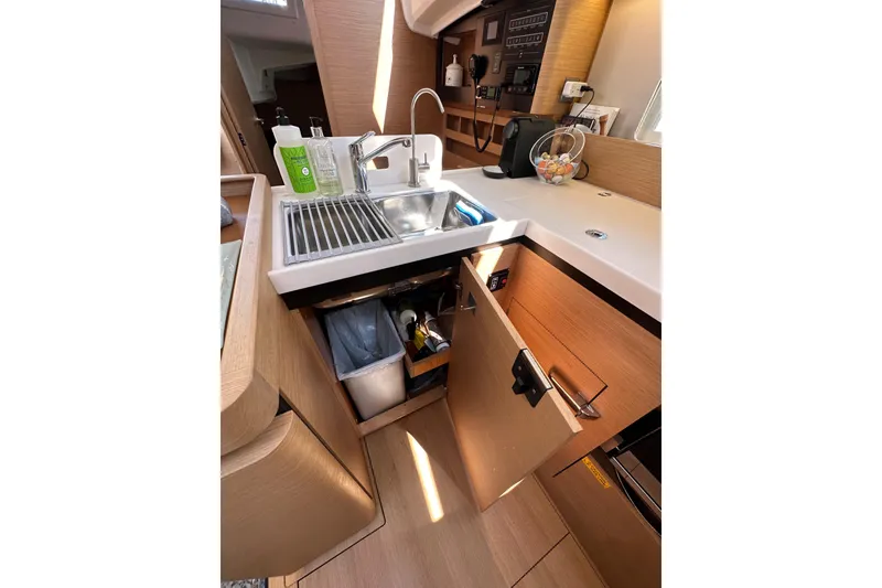 Slide: The Image of Modern kitchen area in 2022 Jeanneau Sun Odyssey 410 yacht, featuring sink and storage. - 58