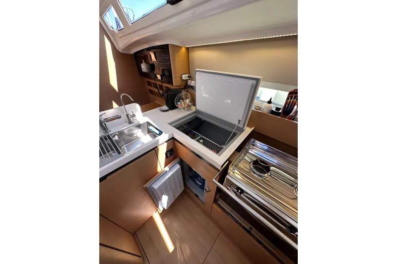 Slide: The Image of Modern kitchen interior of 2022 Jeanneau Sun Odyssey 410 yacht, featuring sleek appliances. - 59