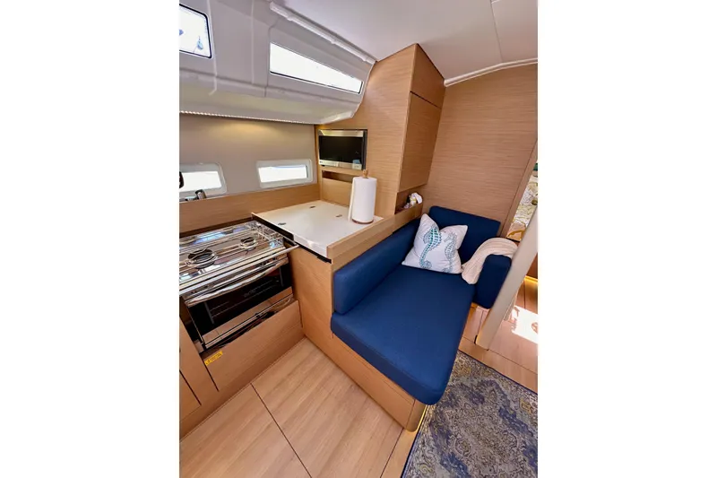 Slide: The Image of Interior of 2022 Jeanneau Sun Odyssey 410 yacht with modern kitchen and cozy seating area. - 62