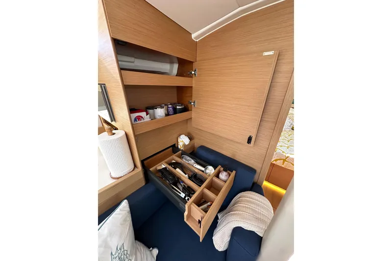 Slide: The Image of Interior of 2022 Jeanneau Sun Odyssey 410 yacht with organized storage and seating area. - 66