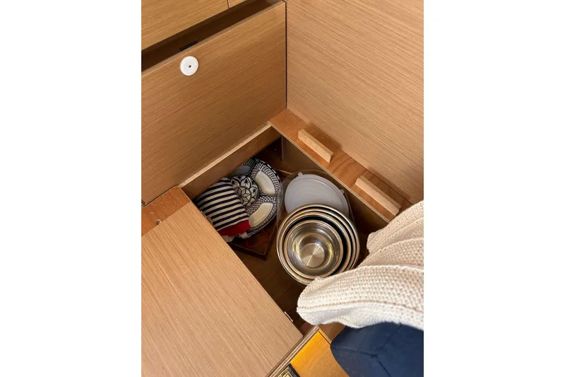 Slide: The Image of Storage compartment in Jeanneau Sun Odyssey 410 yacht, featuring neatly organized kitchenware. - 68