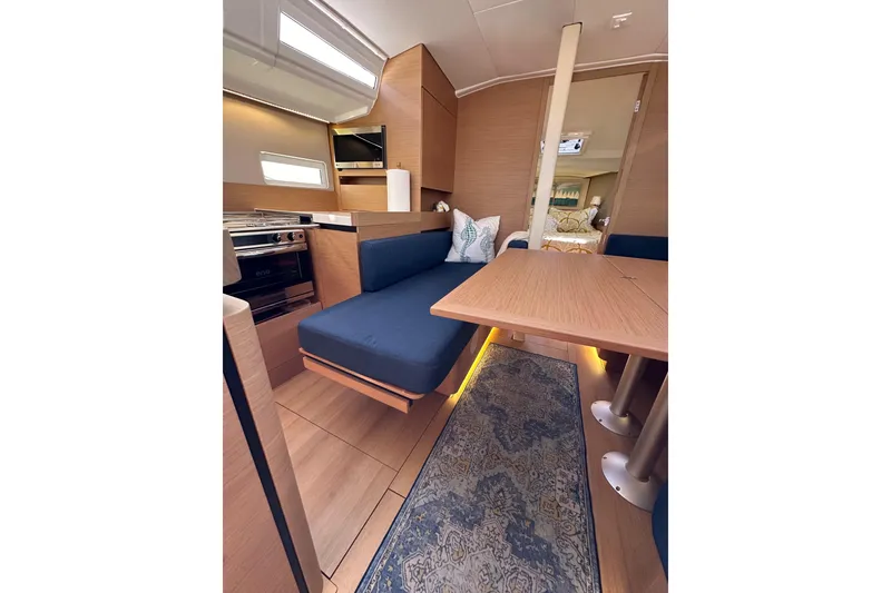 Slide: The Image of Interior of 2022 Jeanneau Sun Odyssey 410 yacht, featuring modern kitchen and cozy seating area. - 70