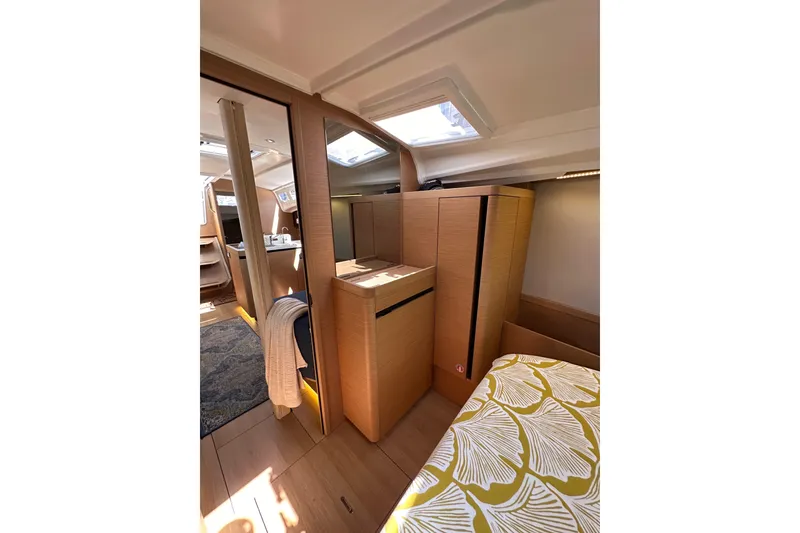 Slide: The Image of Interior of 2022 Jeanneau Sun Odyssey 410 yacht, featuring modern wood cabinetry and skylights. - 77