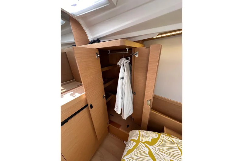 Slide: The Image of Interior of 2022 Jeanneau Sun Odyssey 410 showing wooden wardrobe and cozy bedding. - 79