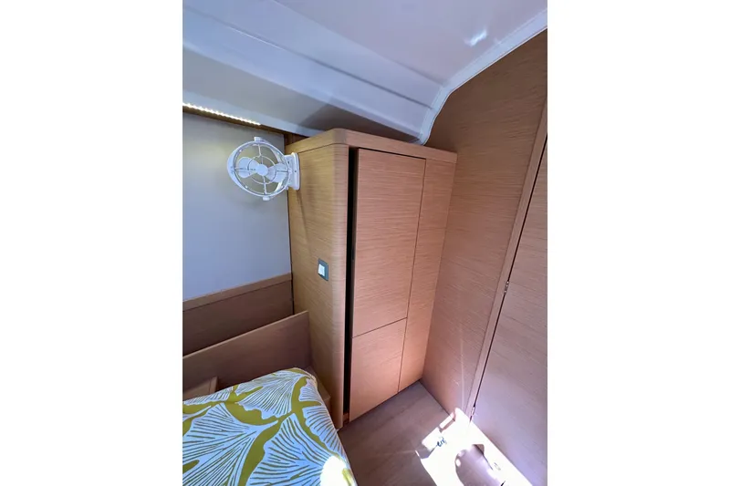 Slide: The Image of Interior cabin of 2022 Jeanneau Sun Odyssey 410 with wooden cabinetry and wall-mounted fan. - 83
