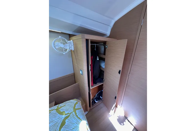 Slide: The Image of Interior of 2022 Jeanneau Sun Odyssey 410 showing a wooden wardrobe and fan. - 84