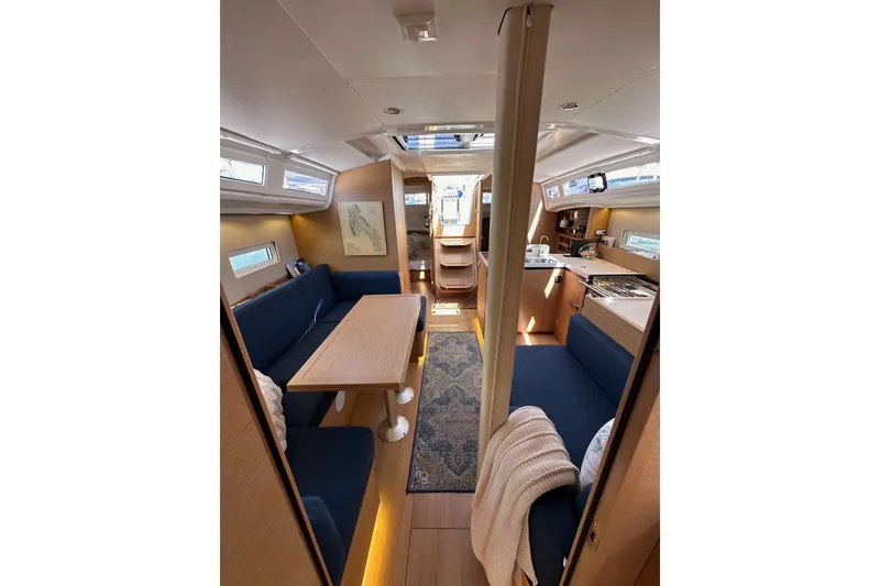 Slide: The Image of Interior of 2022 Jeanneau Sun Odyssey 410 sailboat with modern seating and kitchen area. - 85