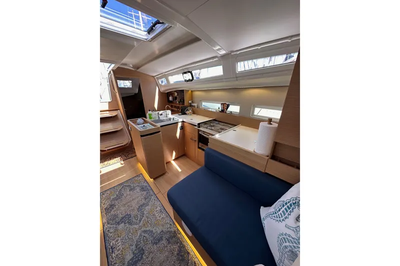 Slide: The Image of Interior of 2022 Jeanneau Sun Odyssey 410 yacht, featuring modern kitchen and seating area. - 88