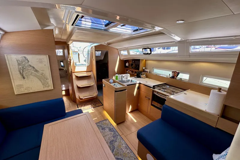 Slide: The Image of Interior of 2022 Jeanneau Sun Odyssey 410 yacht, featuring modern kitchen and seating area. - 89