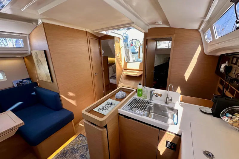 Slide: The Image of Interior of 2022 Jeanneau Sun Odyssey 410 sailboat, featuring modern kitchen and seating area. - 90