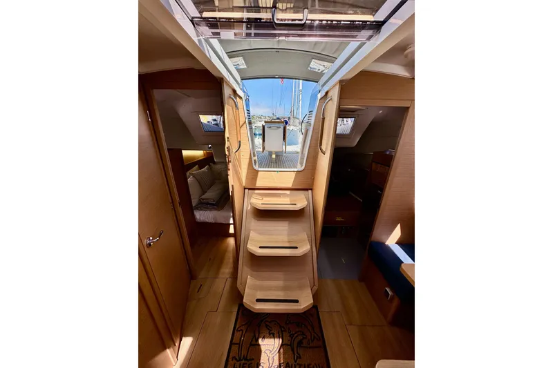 Slide: The Image of Interior view of 2022 Jeanneau Sun Odyssey 410 sailboat, featuring wooden steps and cozy cabins. - 91