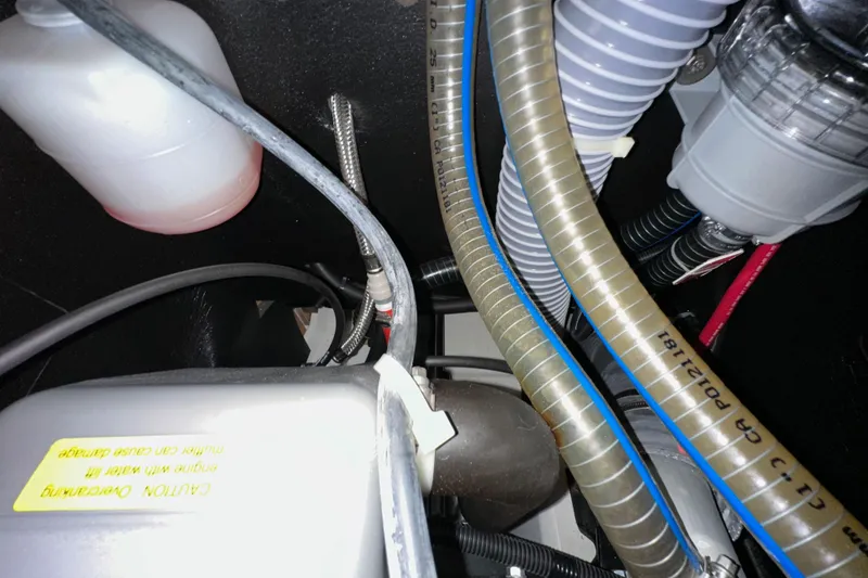 Slide: The Image of Engine compartment of 2022 Jeanneau Sun Odyssey 410 with hoses and fluid container. - 94