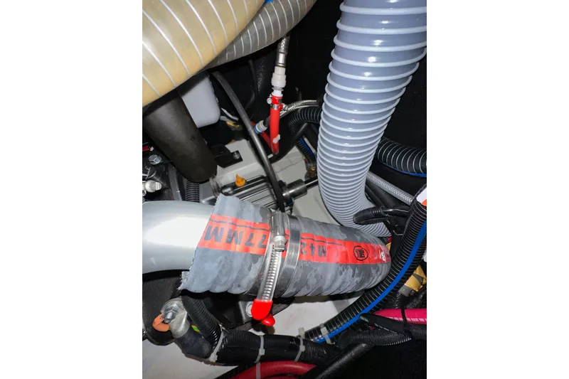 Slide: The Image of Engine compartment of 2022 Jeanneau Sun Odyssey 410 with hoses and wiring. - 96
