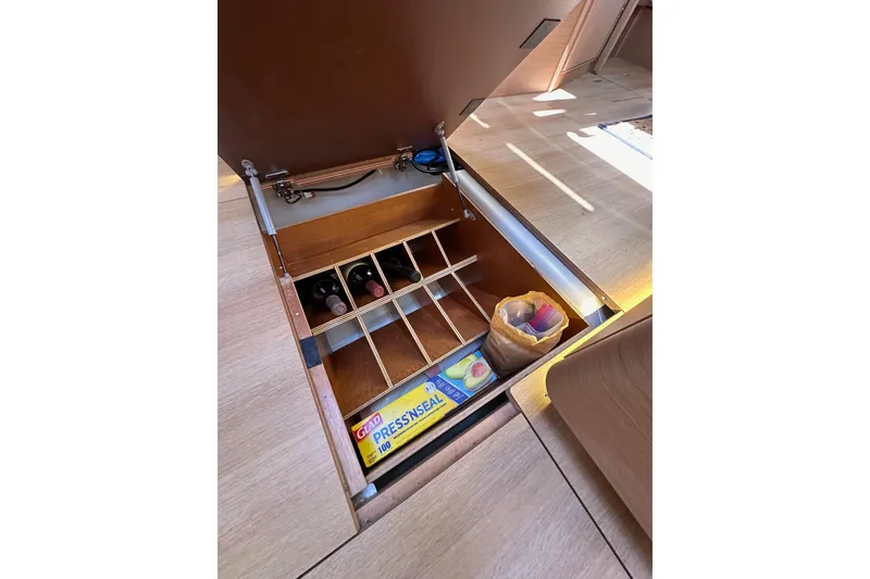 Slide: The Image of Underfloor storage on 2022 Jeanneau Sun Odyssey 410 yacht with wine rack and supplies. - 99