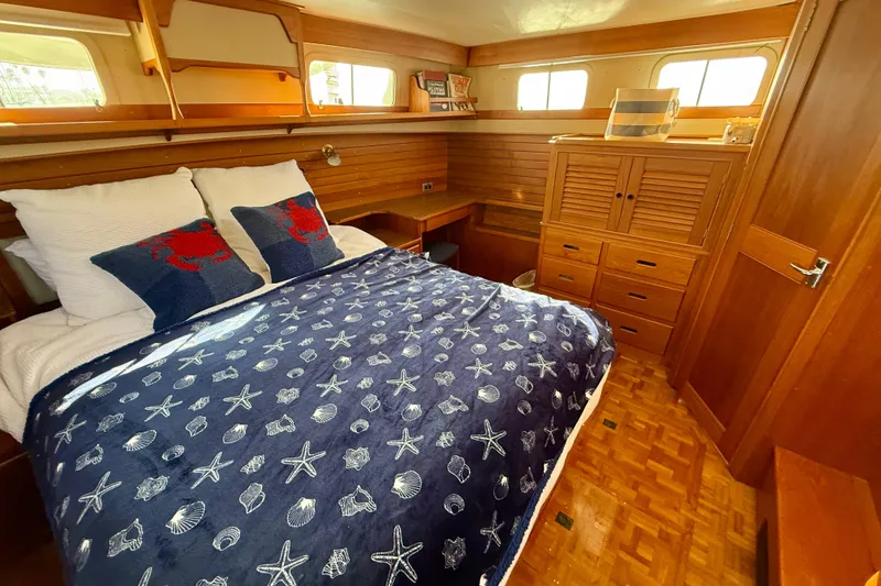 Slide: The Image of Cozy bedroom in 1982 Grand Banks 42 Motoryacht with nautical-themed bedding and wooden furnishings. - 27