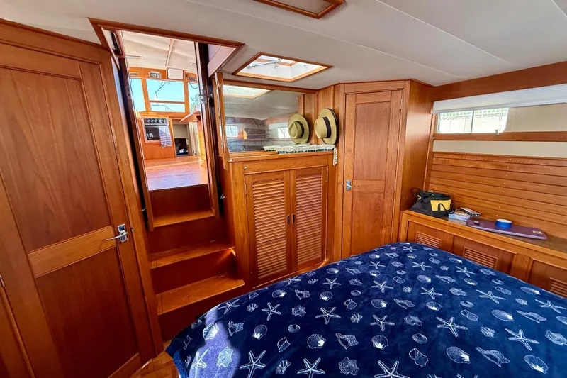 Slide: The Image of Interior of 1982 Grand Banks 42 Motoryacht with wooden cabinetry and nautical-themed bedding. - 31