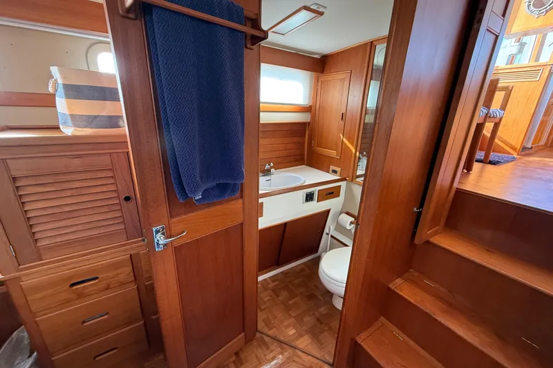 Slide: The Image of 1982 Grand Banks 42 Motoryacht bathroom with wooden cabinetry and nautical decor. - 33