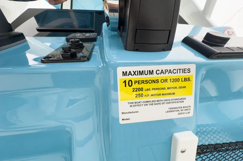 Slide: The Image of 2026 Tidewater 220 LXF boat with canopy, parked in a marina lot. - 21