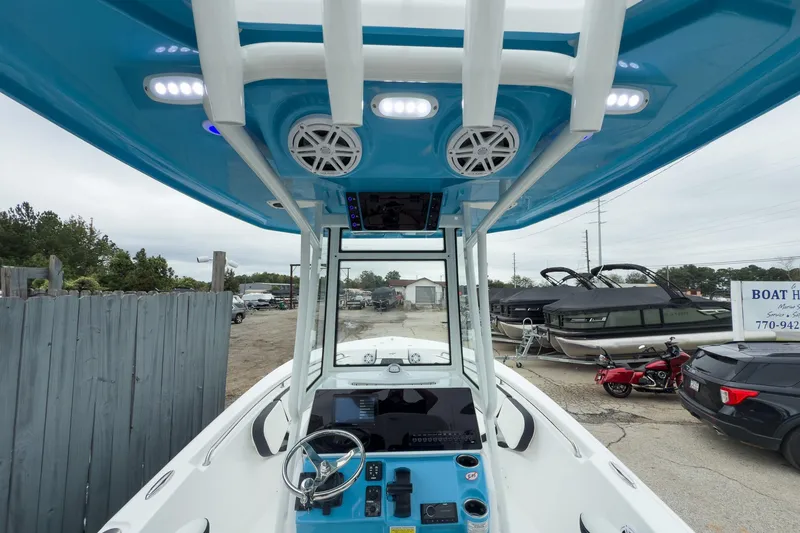 Slide: The Image of 2026 Tidewater 220 LXF boat with white seating and outboard motor in a marina. - 5