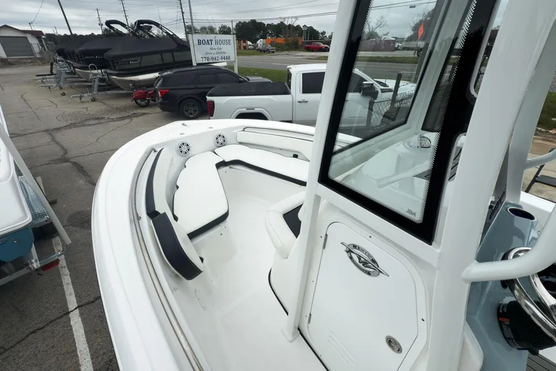 Slide: The Image of 2026 Tidewater 198 CC Adventure boat interior with seating and console, parked at a dealership. - 9