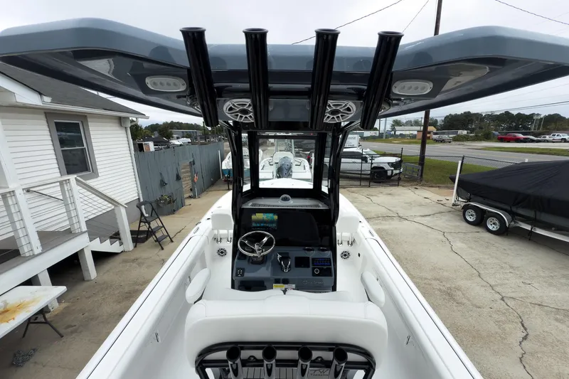 Slide: The Image of 2026 Tidewater 2500 Carolina Bay boat with modern helm and T-top in a driveway setting. - 14