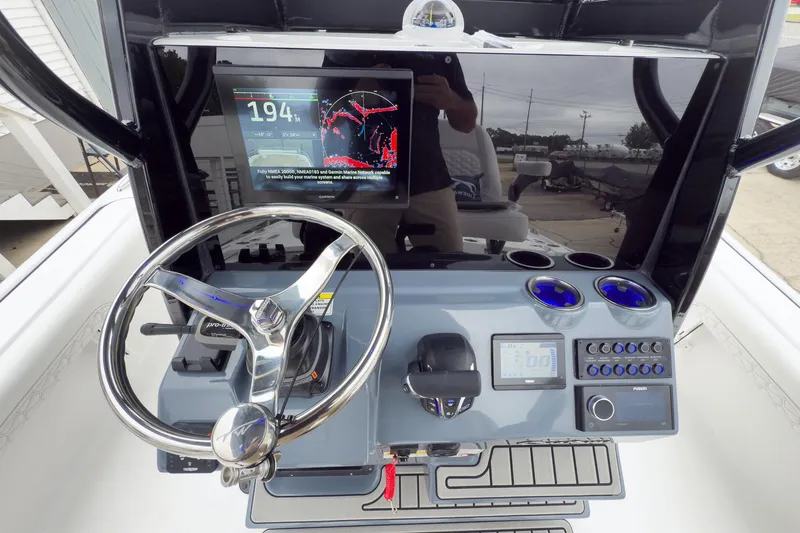 Slide: The Image of 2026 Tidewater 2500 Carolina Bay boat dashboard with steering wheel and navigation display. - 15