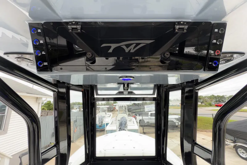 Slide: The Image of 2026 Tidewater 2500 Carolina Bay boat console with control panel and overhead storage. - 19