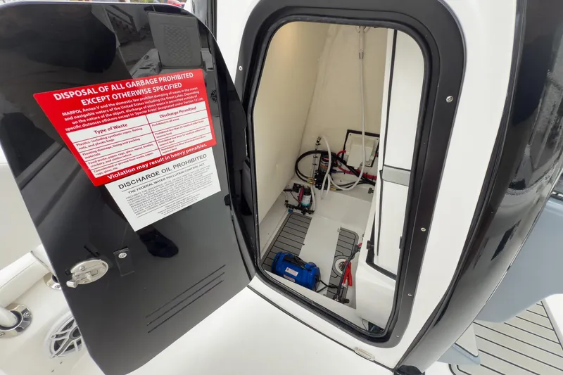 Slide: The Image of 2026 Tidewater 2500 Carolina Bay boat storage compartment with safety instructions. - 23