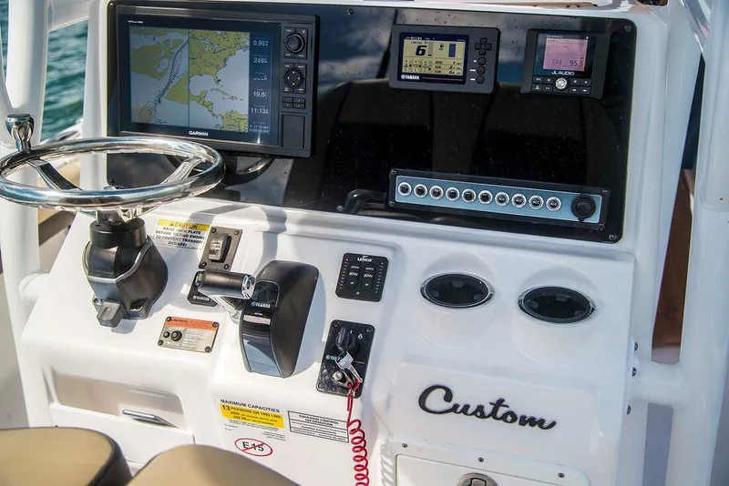 Slide: The Image of 2026 Tidewater 2500 Carolina Bay boat deck with storage compartments and motor. - 9