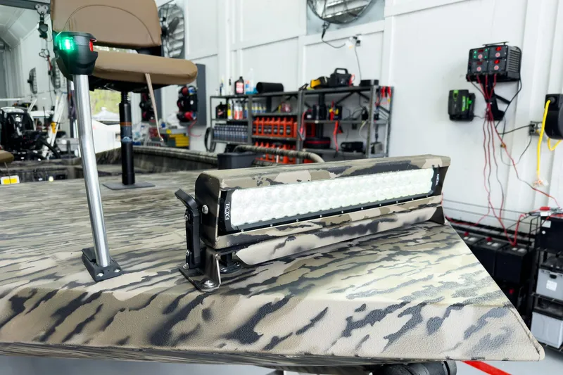 Slide: The Image of Camouflage-patterned Excel 1751 Viper F4 boat with LED light bar in a workshop setting. - 10