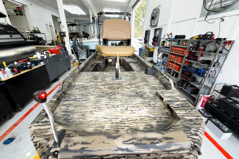 Slide: The Image of 2026 Excel 1751 Viper F4 boat in workshop, camo design, surrounded by tools and equipment. - 12