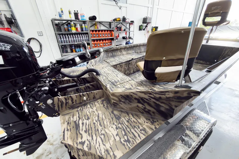 Slide: The Image of 2026 Excel 1751 Viper F4 boat in workshop, featuring camouflage design and organized shelves. - 13