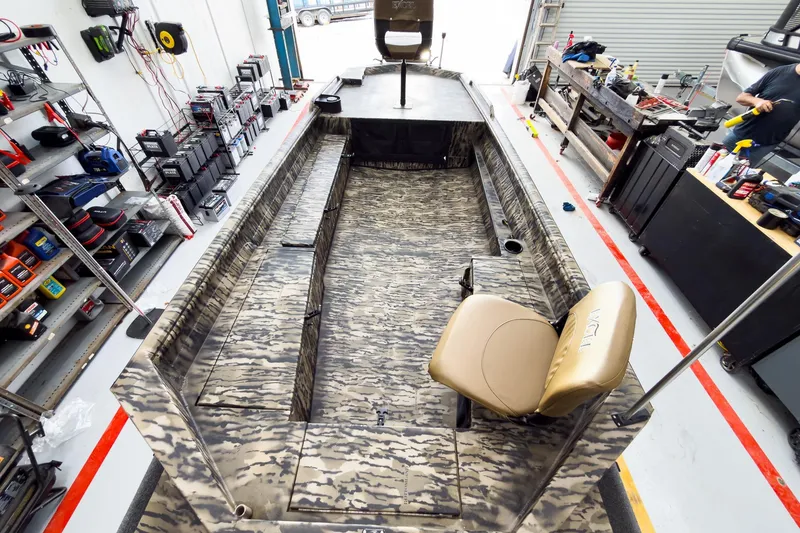 Slide: The Image of 2026 Excel 1751 Viper F4 boat interior in workshop, featuring camo design and seating. - 14