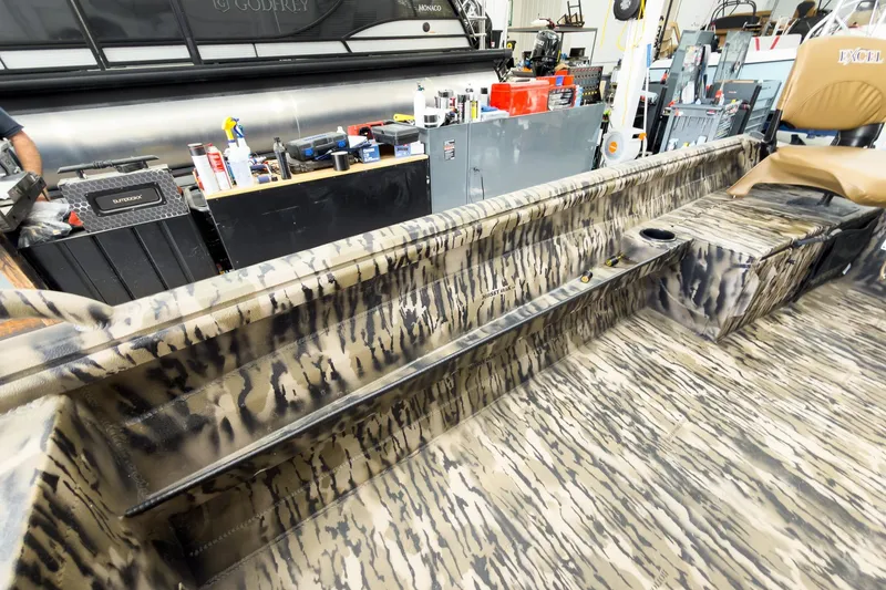 Slide: The Image of 2026 Excel 1751 Viper F4 boat interior with camouflage design in a workshop setting. - 19