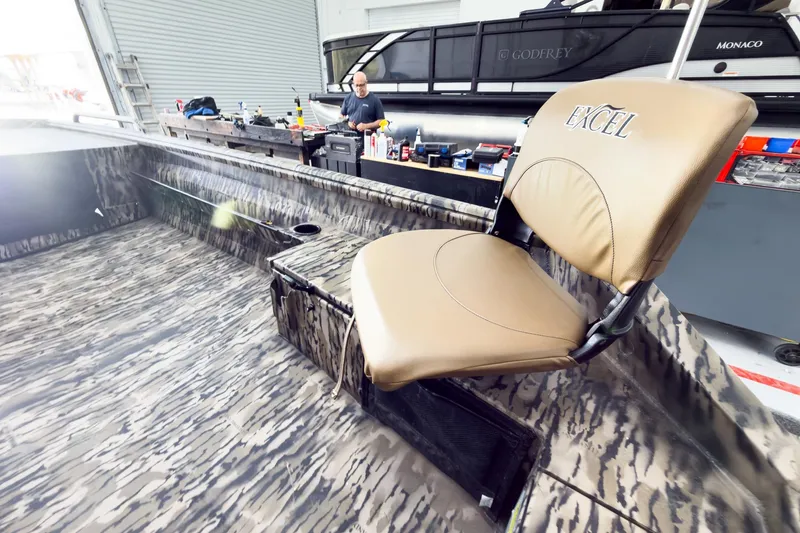 Slide: The Image of 2026 Excel 1751 Viper F4 boat interior with camo design and tan seat in workshop. - 25