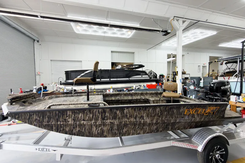Slide: The Image of 2026 Excel 1751 Viper F4 boat in a workshop, featuring camouflage design. - 3