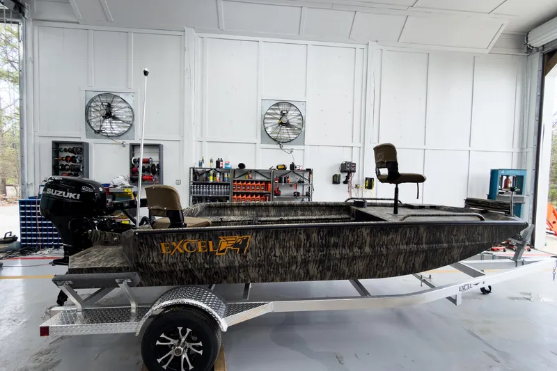 Slide: The Image of 2026 Excel 1751 Viper F4 boat in a garage, featuring Suzuki outboard motor. - 7