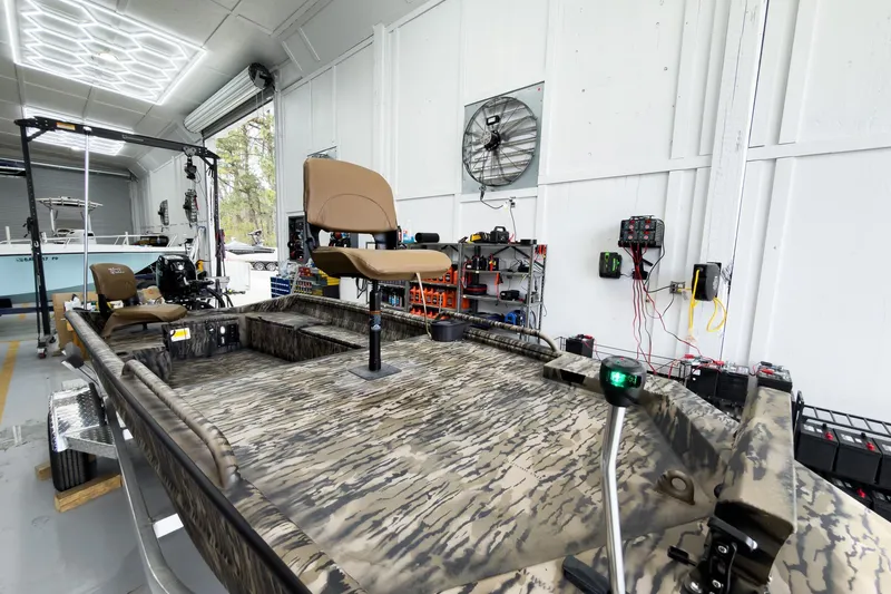 Slide: The Image of 2026 Excel 1751 Viper F4 boat in a workshop, featuring camouflage design and modern seating. - 9