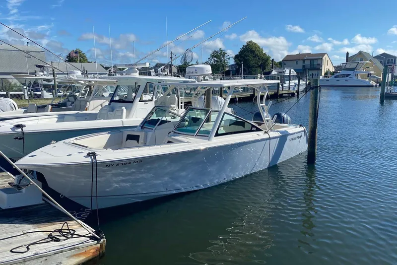 The Image of 2022 Sailfish 276 DC boat docked in a marina under a clear blue sky. - 0