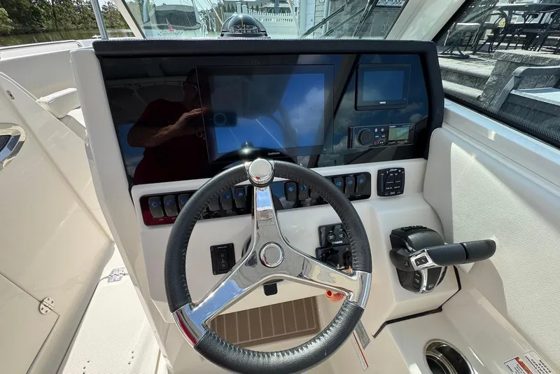 Slide: The Image of 2022 Sailfish 276 DC boat dashboard with steering wheel and control panel. - 16