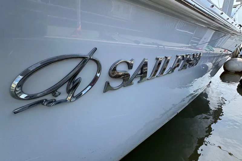 Slide: The Image of 2022 Sailfish 276 DC boat with chrome logo on the side, docked in water. - 18