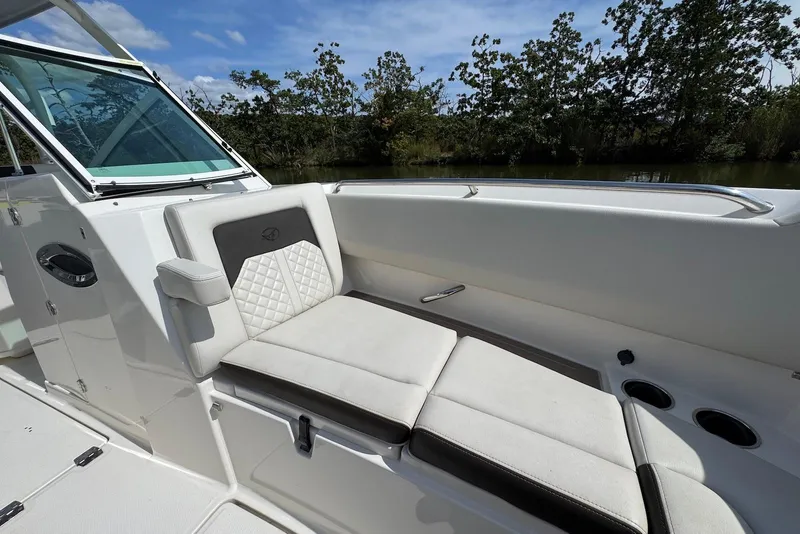 Slide: The Image of 2022 Sailfish 276 DC boat interior with cushioned seating and cup holders. - 21