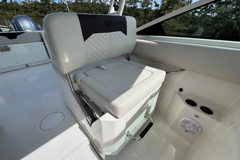 Slide: The Image of 2022 Sailfish 276 DC boat interior with white cushioned seating and cup holders. - 23