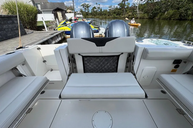 Slide: The Image of 2022 Sailfish 276 DC boat interior with seating, dock, and water view. - 29