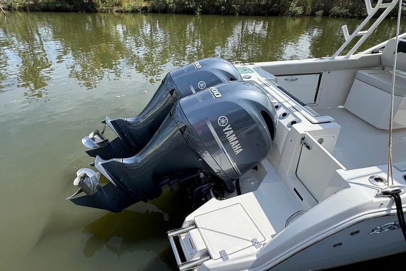 Slide: The Image of 2022 Sailfish 276 DC boat with dual Yamaha 300 outboard engines on calm water. - 34