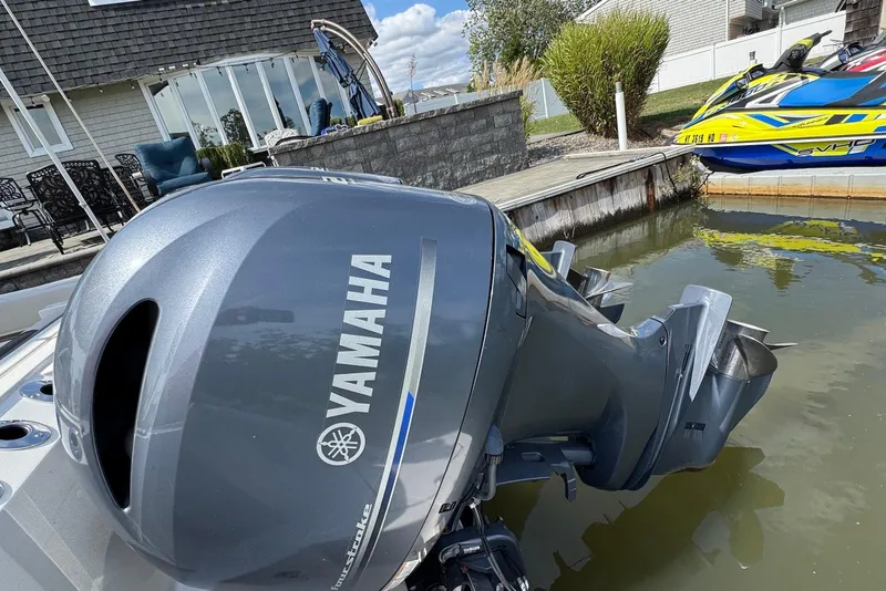 Slide: The Image of Yamaha outboard motor on 2022 Sailfish 276 DC boat docked near jet ski. - 35