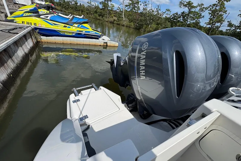 Slide: The Image of 2022 Sailfish 276 DC with Yamaha outboard engines docked near jet skis. - 36