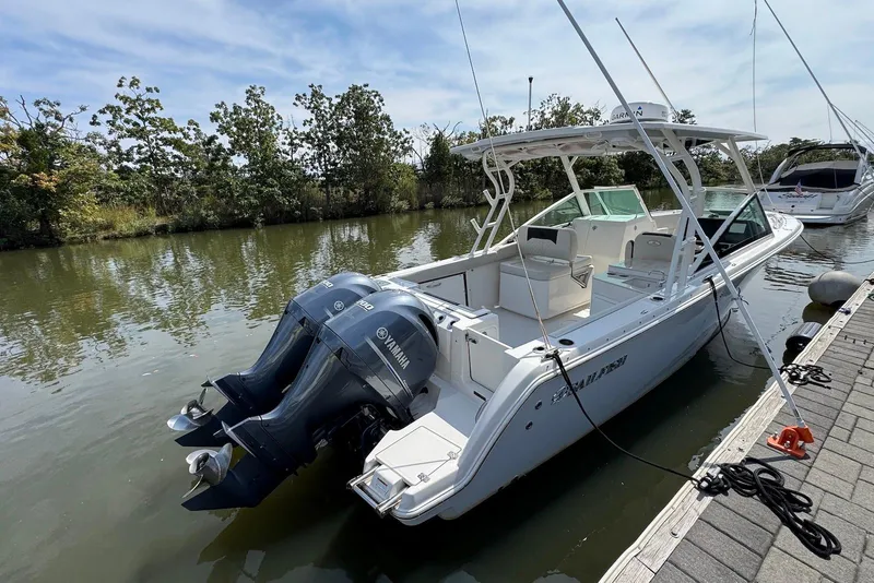 Slide: The Image of 2022 Sailfish 276 DC boat docked, featuring dual Yamaha engines, sleek design, and spacious deck. - 4